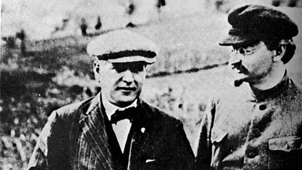 Schwarz-Weiß Foto von Christian Rakowski (frontal) und Leo Trotzki (im Profil) im Gespräch.
